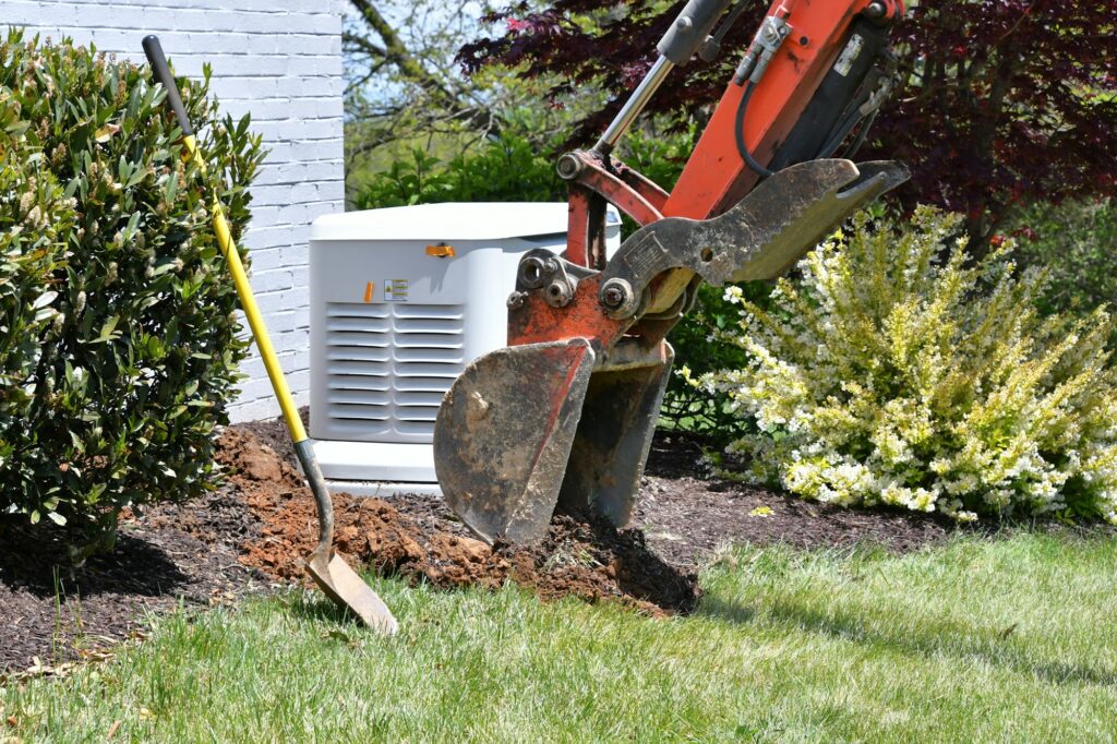 Backhoe digging dirt in lawn to install electrical & gas lines for house generator Scoopful soil sod
